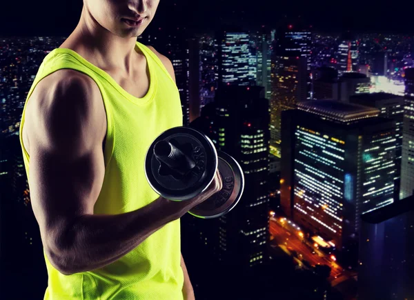 Close up of young man with dumbbell flexing biceps — Stock Photo, Image