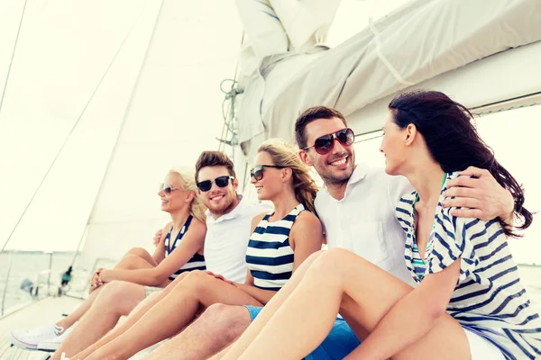 Amici sorridenti seduti sul ponte dello yacht — Foto Stock