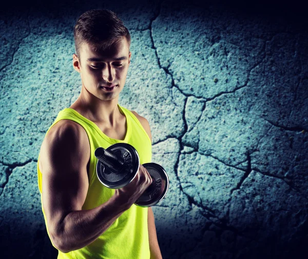 Młody człowiek z wyginanie biceps hantle — Zdjęcie stockowe
