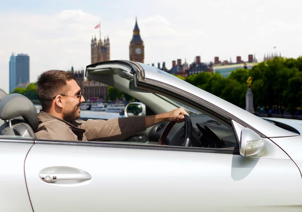 Homem feliz perto de carro cabriolet sobre a cidade de Londres — Fotografia de Stock