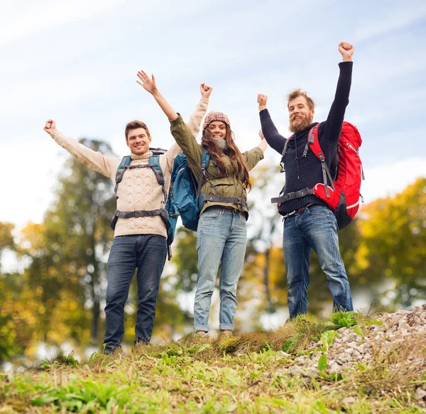 Grupo de amigos sonrientes con mochilas senderismo — Foto de Stock