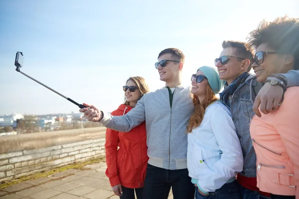 Lachende vrienden nemen selfie met smartphone — Stockfoto