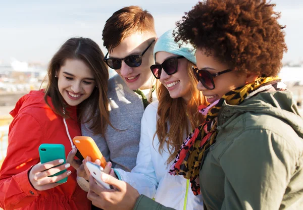 Amici sorridenti con gli smartphone — Foto Stock