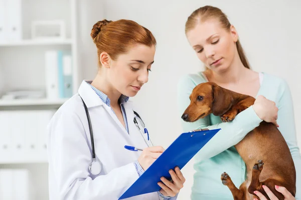 Woman with dog and doctor at vet clinic — Zdjęcie stockowe