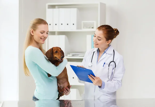 Szczęśliwa kobieta z psem i lekarz w klinice weterynarza — Zdjęcie stockowe