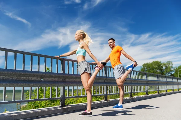 Smiling couple stretching outdoors — Stockfoto