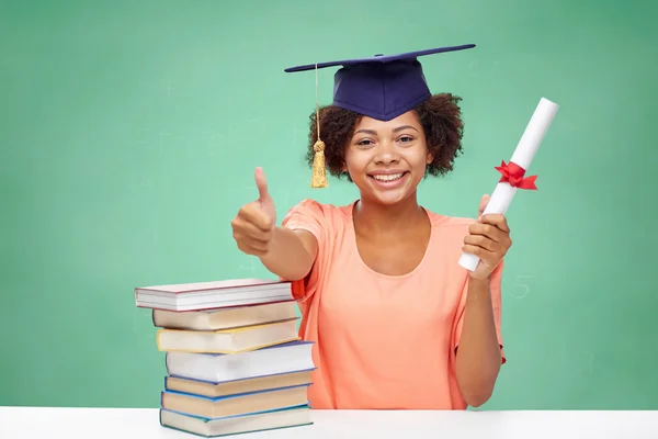 Gelukkig Afrikaanse bachelor meisje met boeken en diploma Stockfoto