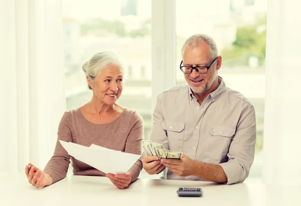 Senior couple with money and calculator at home — Stock Photo, Image