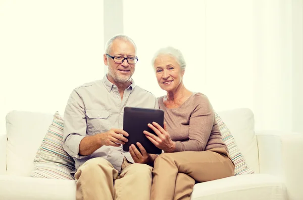 Feliz pareja de ancianos con PC tableta en casa —  Fotos de Stock