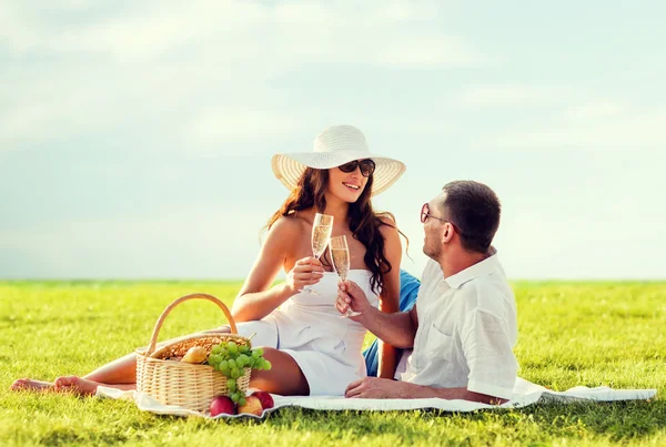 Sonriente pareja bebiendo champán en el picnic —  Fotos de Stock