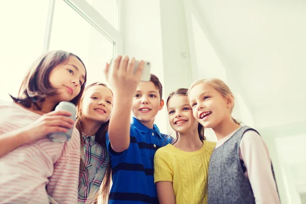 Grupp av skolbarnen med smartphone och soda burkar — Stockfoto