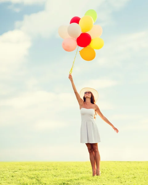 Sorrindo jovem mulher em óculos de sol com balões — Fotografia de Stock