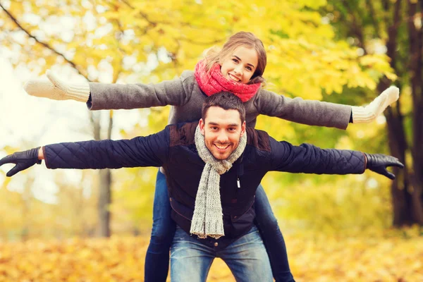 Sonriente pareja divirtiéndose en el parque de otoño — Foto de Stock