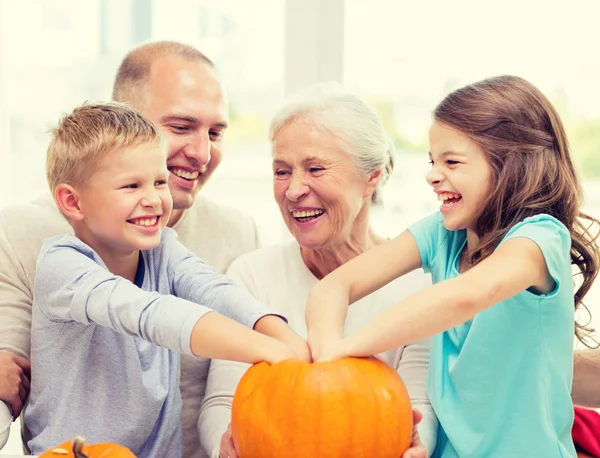 Família feliz sentado com abóboras em casa — Fotografia de Stock