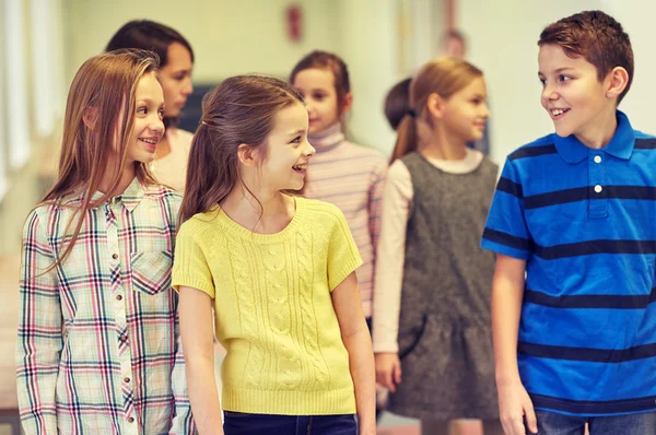 Grupp av leende skola barn gå i korridoren — Stockfoto