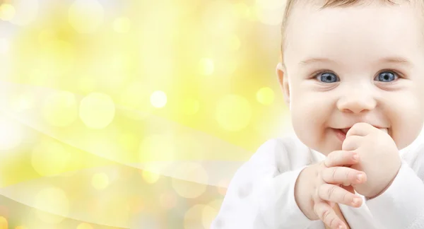 黄色の背景の上に幸せな赤ちゃんのクローズ アップ — ストック写真