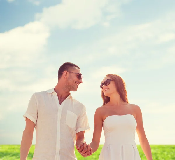 Lachende paar in zonnebril buiten lopen — Stockfoto