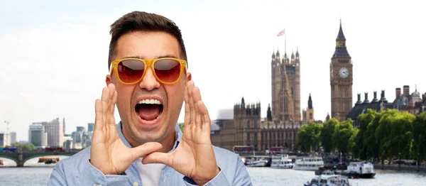 Face of angry shouting man in shirt and sunglasses — Stock fotografie