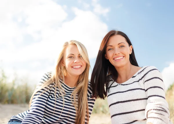 Happy teenage girls or young women on beach — Stock Photo, Image