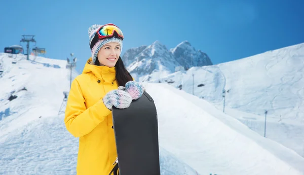 Jeune femme heureuse avec snowboard sur les montagnes — Photo