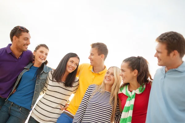 Grupo de amigos felizes abraçando e falando — Fotografia de Stock