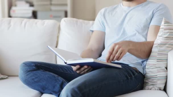 Close up de homem lendo livro em casa — Vídeo de Stock