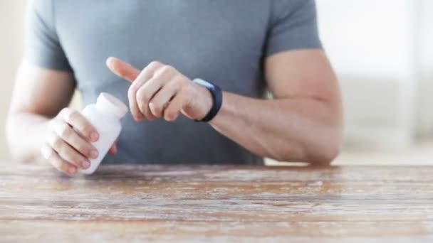 Close up van man gieten pillen uit pot bij de hand — Stockvideo