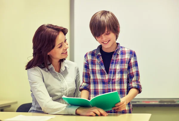 School jongen met notebook en leraar in de klas — Stockfoto