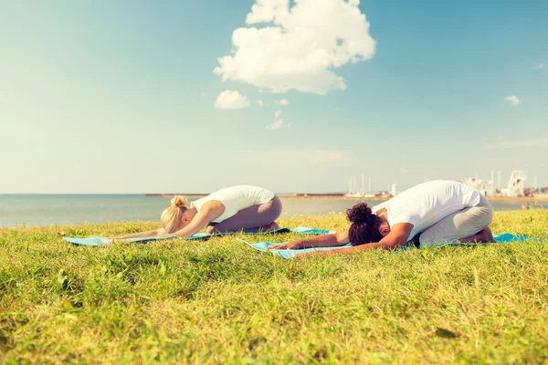 Par gör yogaövningar utomhus — Stockfoto