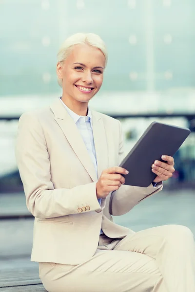 Glimlachende zakenvrouw met tablet pc buitenshuis — Stockfoto