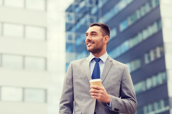 Młody biznesmen uśmiechający się z papieru Puchar na zewnątrz — Zdjęcie stockowe