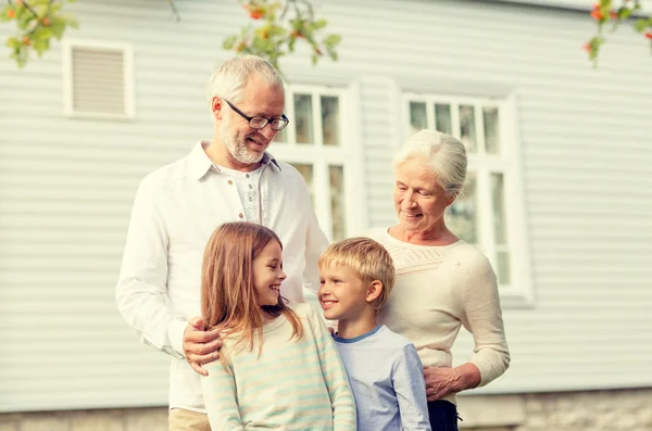 Happy family in front of house outdoors — Stock Photo, Image