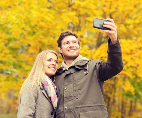 Casal sorridente abraçando no parque de outono — Fotografia de Stock