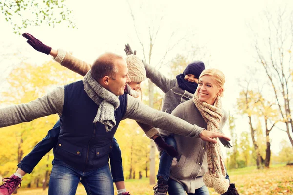 Família feliz se divertindo no parque de outono — Fotografia de Stock