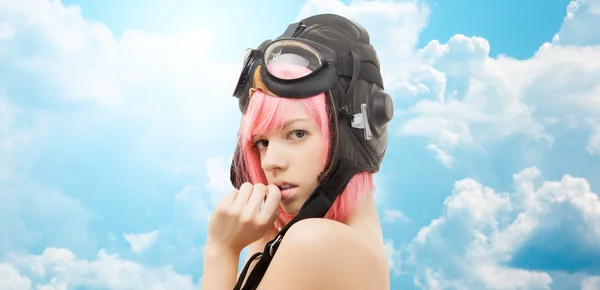 Pink hair girl in aviator helmet over blue sky — Stockfoto