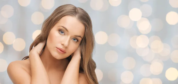 Hermosa cara de mujer joven sobre luces de vacaciones — Foto de Stock