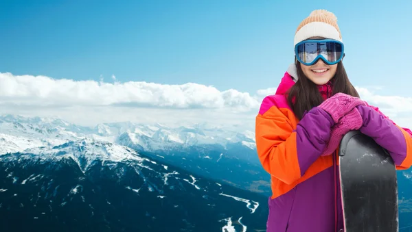 Happy young woman with snowboard over mountains — Stock Photo, Image