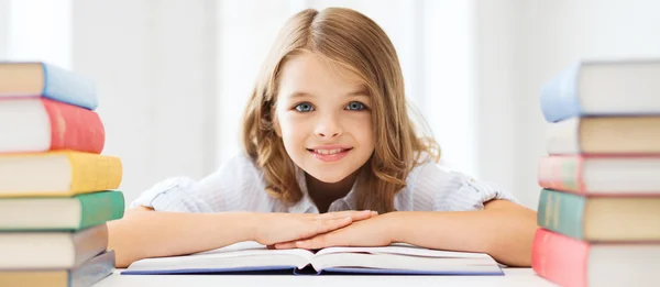 Sonriente niña estudiante con muchos libros — Foto de Stock