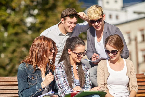 Groupe d'étudiants heureux avec des cahiers sur le campus — Photo