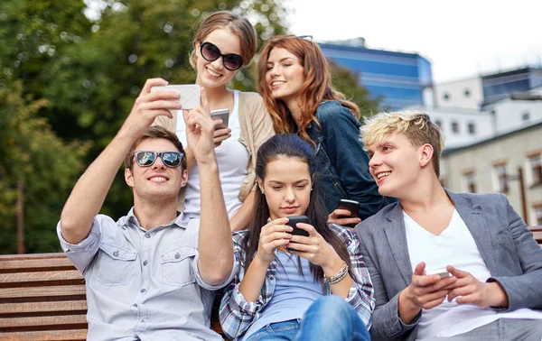 Estudantes ou adolescentes com smartphones no campus — Fotografia de Stock