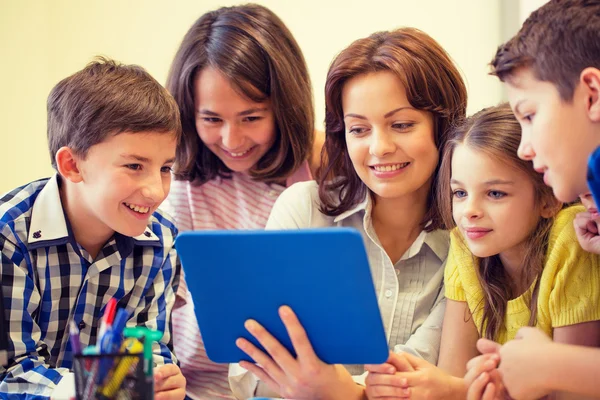 Grupo de crianças com professor e tablet pc na escola Imagem De Stock