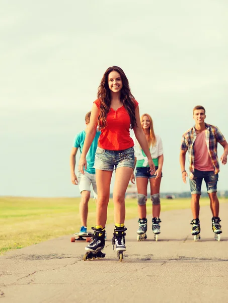 Groep van lachende tieners met skates — Stockfoto