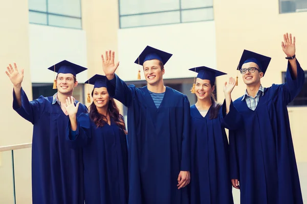 Grup gülümseyen öğrenci mortarboards içinde — Stok fotoğraf