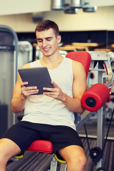 Lächelnder junger Mann mit Tablet-PC im Fitnessstudio — Stockfoto