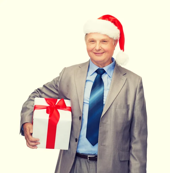 Glimlachende man in pak en santa helper hoed met cadeau — Stockfoto