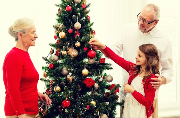 笑みを浮かべて家族飾るクリスマス ツリー自宅 — ストック写真