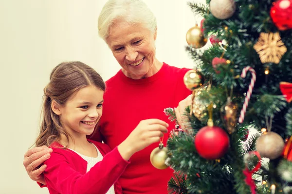 Lächelnde Familie schmückt Weihnachtsbaum zu Hause — Stockfoto