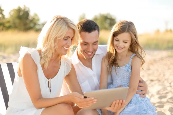 Família sorridente na praia com computador tablet pc — Fotografia de Stock