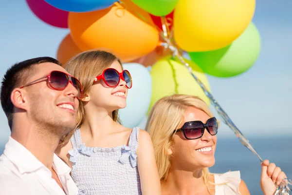 Happy family with colorful balloons outdoors — Stock Photo, Image