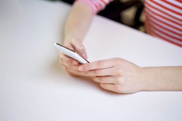 Gros plan des mains féminines avec smartphone à la maison — Photo